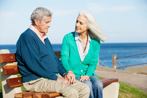 Senior Woman Comforting Depressed Husband Sitting On Bench